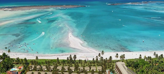 Vista aérea do resort com coqueiros e mar turquesa na Praia de Antunes